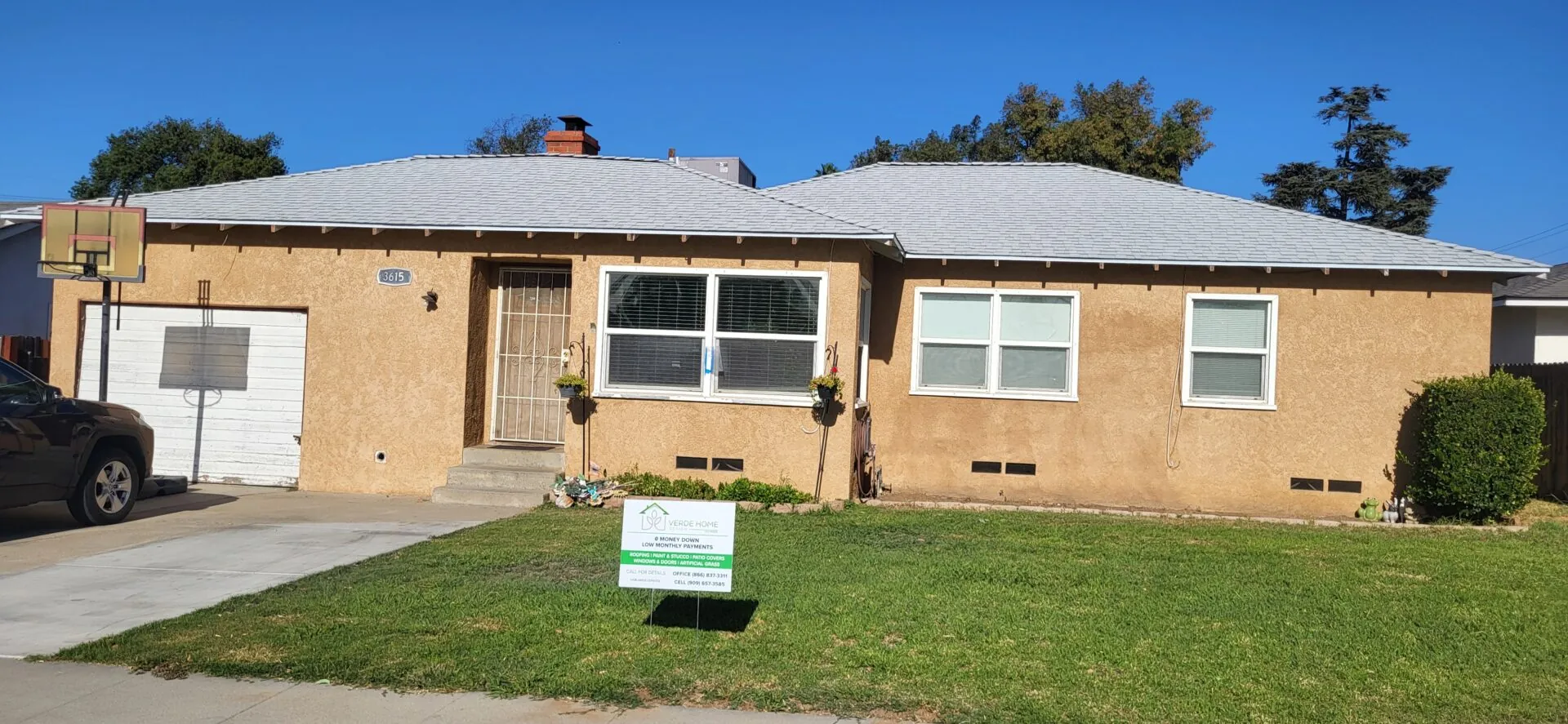 Single-story home with a new gray shingle roof and an Ocelot job sign on the lawn